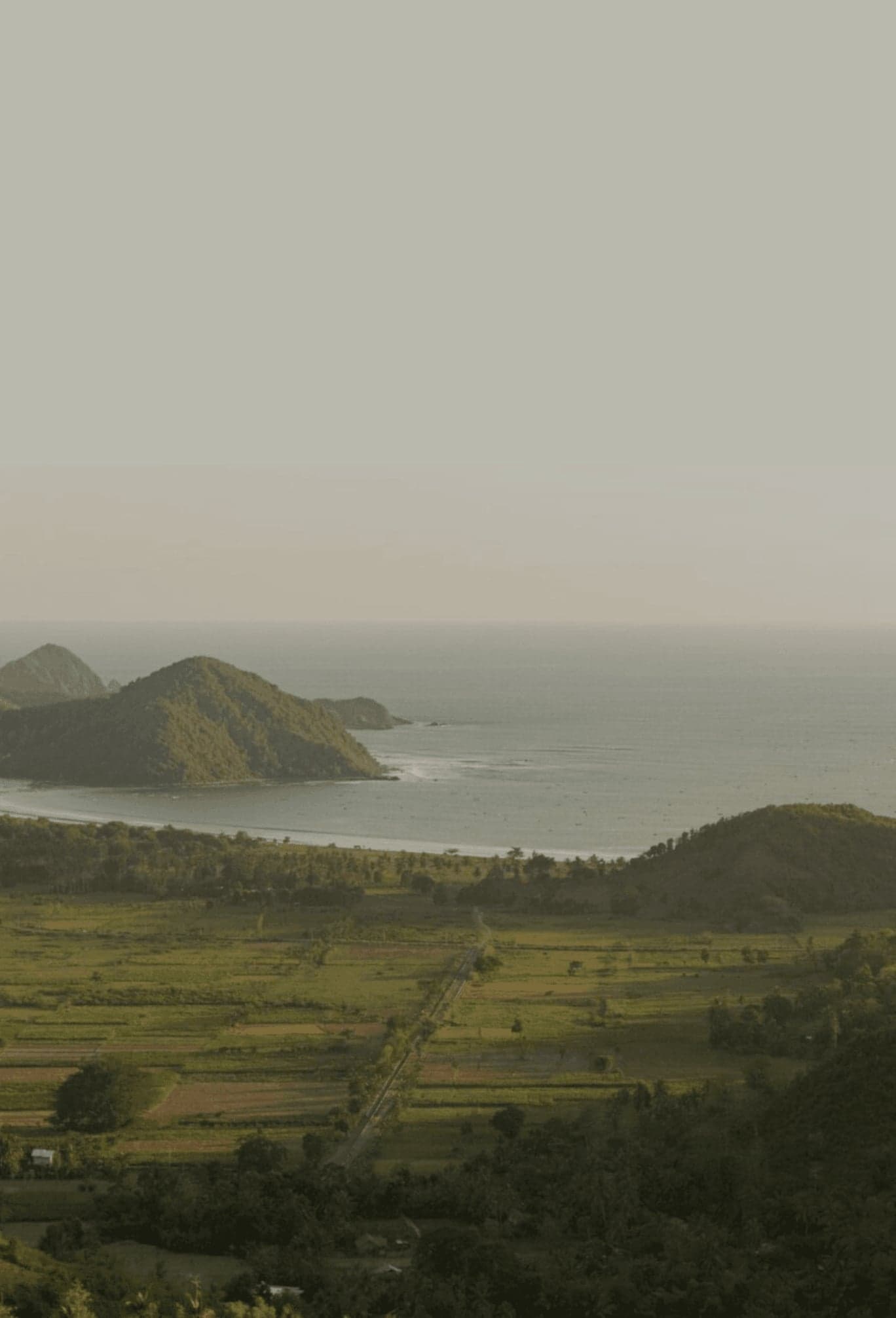 View across Selong Belanak coastline with hills and ocean